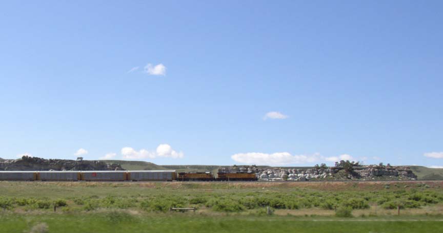 Train about 1/2 mile west of the road, with a rock outcropping beyond.